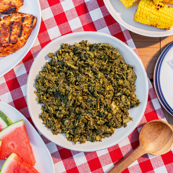 Parker's collard greens on a cookout table with grilled chicken and corn